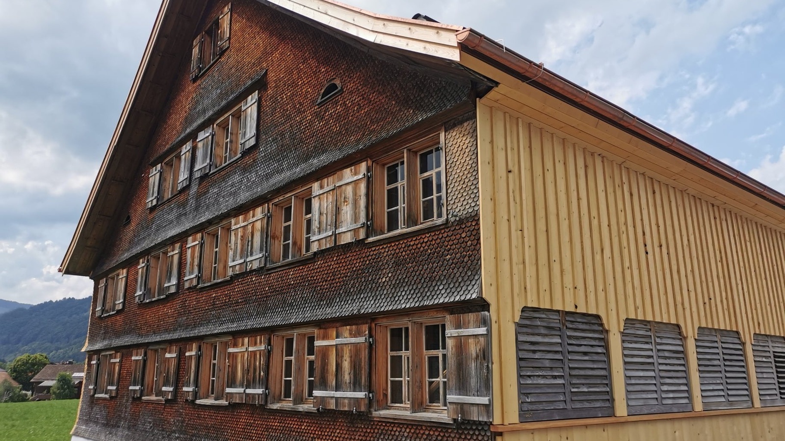 Die alte Dame im neuen Kleid: Die markante Vorderfront des Museums in Bezau mit den sonnengebräunten und verwitterten Schindeln wurde behutsam mit einem modernen Lattenschirm ergänzt – die Brücke von Alt und Neu ist gelungen.