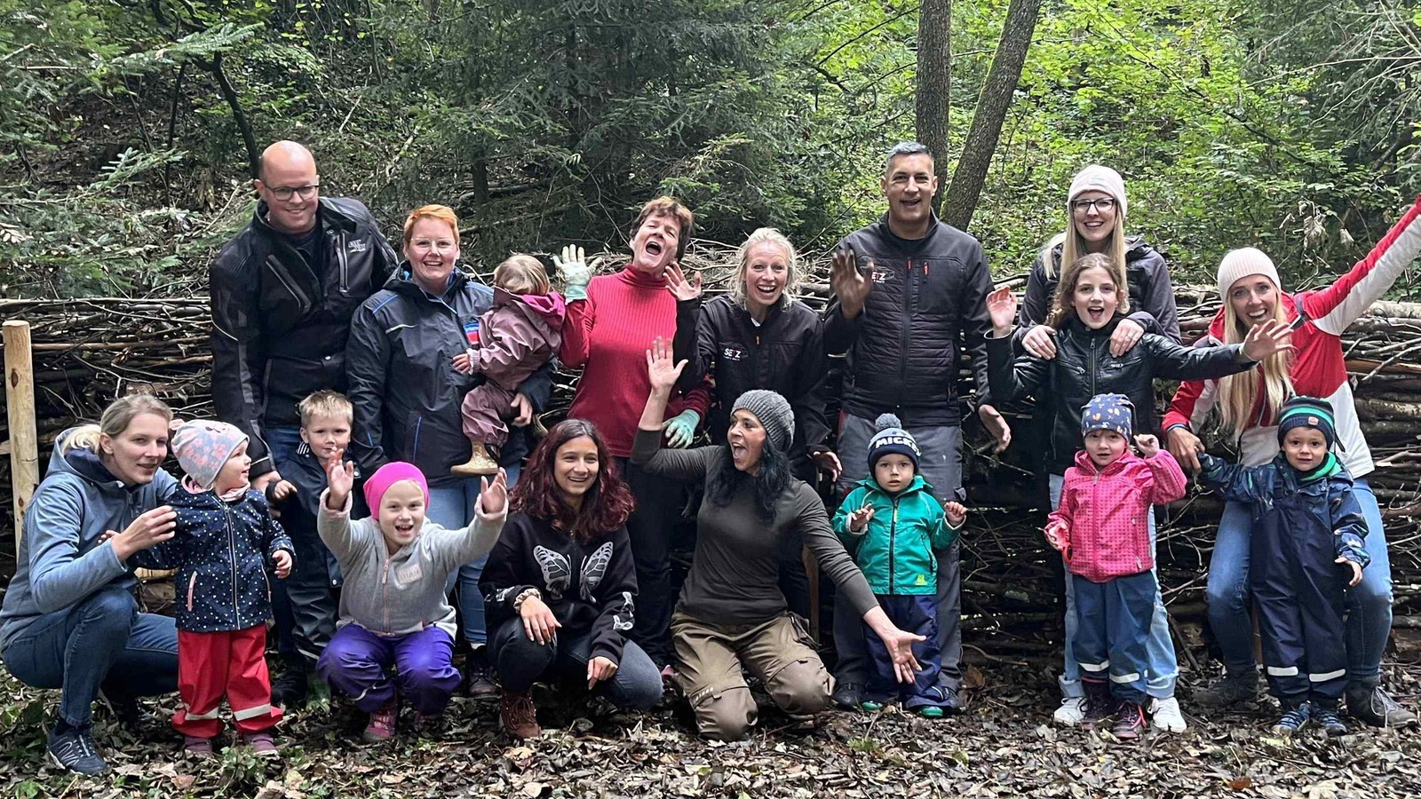 Das Werk ist vollbracht! Kinder und Erwachsene freuen sich über die Totholzhecke, die sie gemeinsam im Bachspielwald in Hohenweiler errichtet haben.