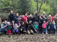 Das Werk ist vollbracht! Kinder und Erwachsene freuen sich über die Totholzhecke, die sie gemeinsam im Bachspielwald in Hohenweiler errichtet haben.